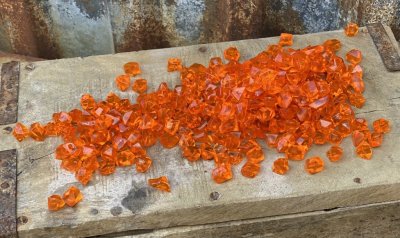 Orangea diamant formade stenar. Mixat i skimrande och matta stenar. Att dekorera med i vattenbad, blomsterarrangemang, ljusdekor