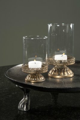 Vacker ljusstake med cylinderglas på fot. För ljus tex. Går i en antik guld färgad lätt ruffig nyans. Stilfullt och snirkligt de