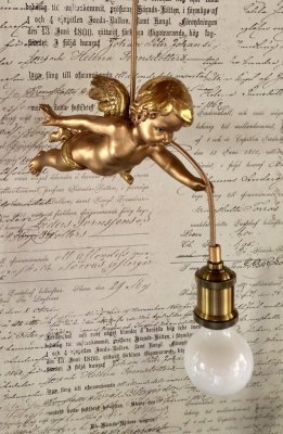 Vacker och annorlunda ängel lampa i hängande modell. Går i en mjuk nyans av guld och antikguld på ett antikt och gammeldags vis.