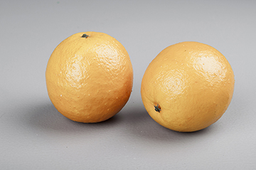 Apelsin orangea i rundad verklighetstrogen modell att dekorera med. Välarbetad, verklighetstrogen, konstgjord modell.