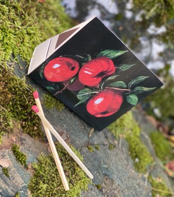 Tändstickor i vacker kantig stående förpackning med motiv av äpplen. Motiv på båda sidorna. Tändstickorna är i längre modell sk