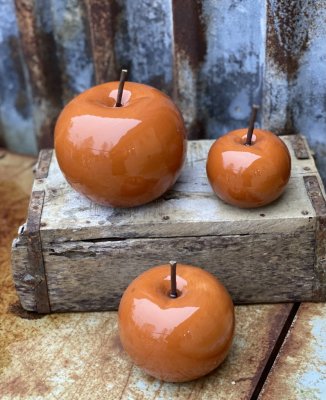 Äpple i porslin. Mörkt orange färgat höst brunt med brun metall pinne i mitten. Finns i tre storlekar. -Större -Mellan -Mindre B