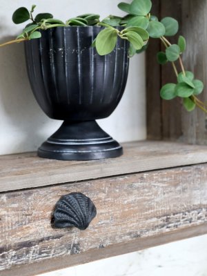 Småformat handtag modell mussla i järn. Går i en antik svart lätt ruffig nyans. Ett handtag som både kan sitta med öppningen upp