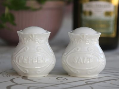 Franskt Salt & Peppar karl i vitt porslin med vackert mönster runt om och text på respektive karl. I fin kurvig form. Säljes i p