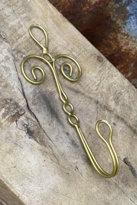 Vacker och elegant enkel krok i guld färgad metall med lätt dekorerad rygg. I fil de fer modell. Från Madam Stoltz  Mäter 5,5*12