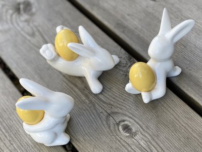 Vita lekfulla kaniner med guld ägg i porslin. Finns i tre olika modeller. - Sitter - Ägg på ryggen -Ligger på mage Lika söta och