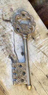 Kapsylöppnare i guld formad som en gammal Nyckel med vacker dekoration. I tyngre detaljrik modell som är lika vacker bara som en