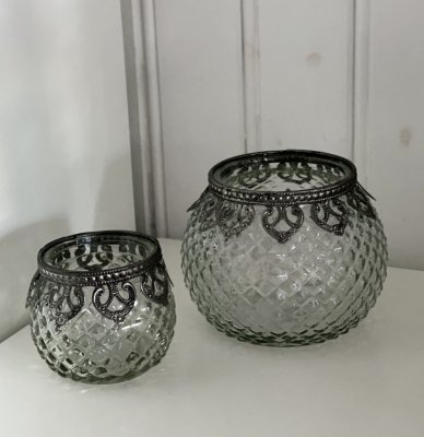 Orientalisk ljuslykta i kraftigt mönstrat glas. Dekorerat med en silver färgat bord runt om. Finns i två storlekar. -Större -Min