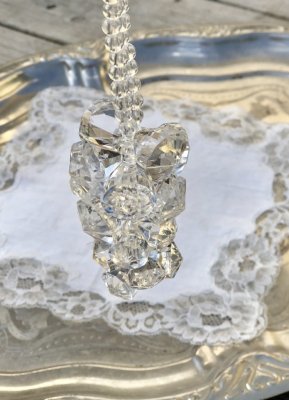 Vackert dekorations hänge med klara diamant formade  prismor trädda på tråd. Prismorna är formade som en klase med vackert fallS