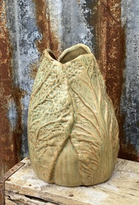 Vacker och annorlunda vas designad trädgård. vasen ser ut att ha salladsblad / kålblad runt om i en murrigt grön nyans med bruna