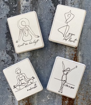 Vita kylskåpsmagneter i trä med yoga och livs motiv med text. Svart text och  fabriks slitna inslag. Magnet på baksidan. Finns i