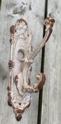 Vacker gammeldags ruffig krok i järn/metall. Ruffigt vit med fabriks skavda inslag. Bred ryggplatta och två krokar.   mäter ca 2