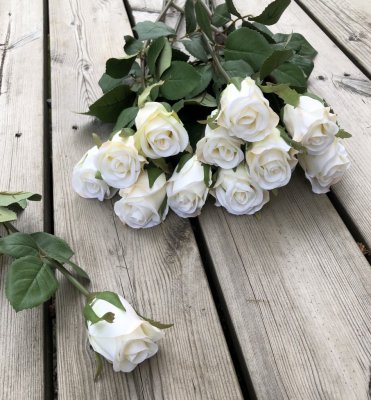 Vacker vit verklighetstrogen konstblomma ros i outslagen knoppig modell med skaft och blad. Att dekorera med ensam eller tillsam