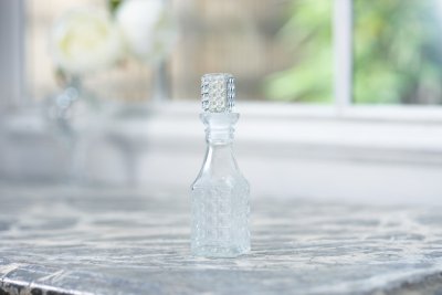 Vacker gammeldags glasflaska i modell parfymflaska. Kantig med vackert mönster runt om. Och med en glasknopp upptill även den me