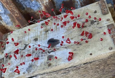 Vacker girlang med röda pärlor och hjärtan på silver tråd. Att dekorera eller duka med lägga på ett ljusfat eller vira in i en b
