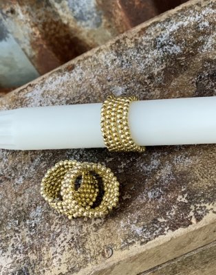 Dekoration till ljus tex. En vacker guld färgad ring som är elastisk och töjbar. Små guld pärlor träda på en styvare metalltråd.
