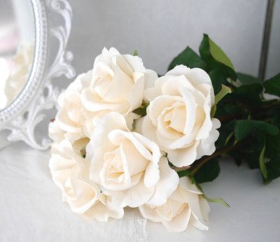 Vacker vit verklighetstrogen konstblomma ros i utslagen vacker och romantisk  modell med skaft och blad.  Att dekorera med ensam