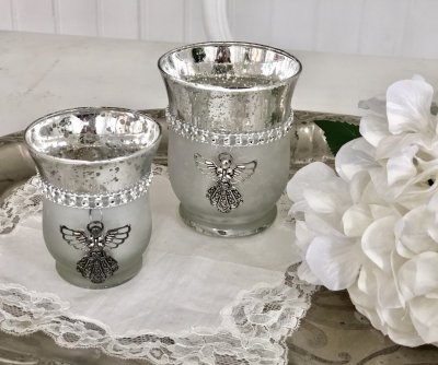 Ljuslykta / ljusglas i fattigmanssilver med strass dekoration och en silver ängel framtill. Finns i två storlekar -Högre -Lägre