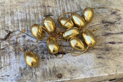 Guld färgade ägg att hänga i tex påskriset. Mindre modell på äggen som hänger i guld färgat snöre. Säljes i pack om 10st ägg.  M