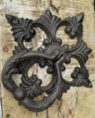 Dörrkläpp / dörrklapp i antik Fransk design. Tillverkad i järn och går i en Mörk brun nyans med ruffiga inslag.   Mäter  ca 16*1