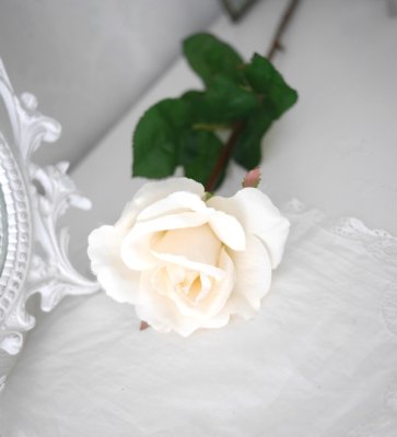 Vacker vit verklighetstrogen konstblomma ros i utslagen vacker och romantisk  modell med skaft och blad.  Att dekorera med ensam