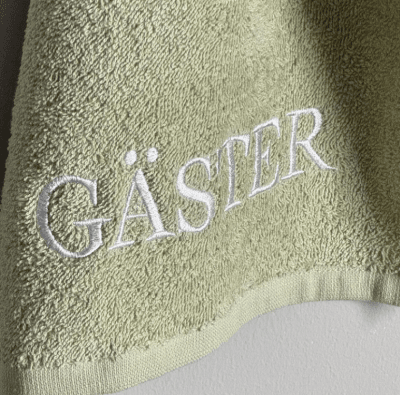 Grön GÄSTER handduk med broderad text