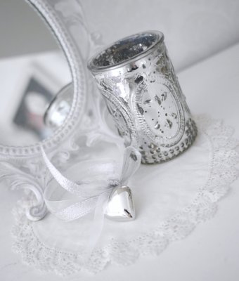Ljusglas i fattigmanssilver . Dekorerat i glaset med mönster av en fransk lilla och med en rosett av sidenband med ett större hj