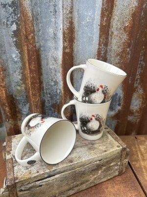 Vit porslins mugg med hönor och ägg