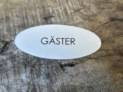 Oval vit skylt GÄSTER i plåt