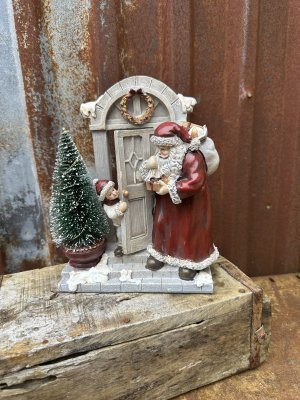 Tomte och pojke vid ytterdörr med belysning