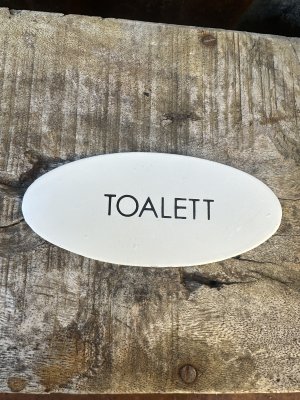 Oval vit TOALETT skylt i plåt