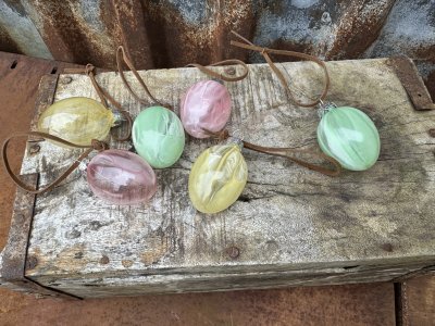Ägg i glas i mjuka pastell nyanser att hänga i påskriset