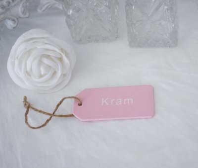 Kram tags/skylt rosa med vit text. Snöre i ändan. Att hänga på paket, blommor, kort eller dyligt. Tillverkad i trä med lätt dri