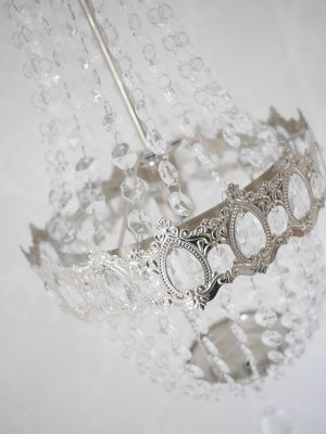 Vacker kristallkrona lampa i elegant modell med flera rader av prismor i olika variationer. Prismorna är i plast men ger sken av