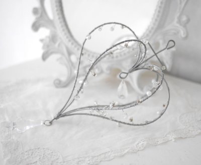 Vacker hjärtformad krona dekoration med kors. Att hänga eller dekorera med liggandes. Stomme i metall dekorerad med träd av pärl