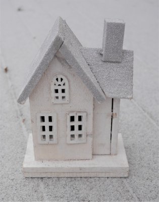 Tomtens vita stuga med belysning. Tillverkad  i trä med fina detaljer runt om och dekorerad med puder snö.  Med en batteri drive