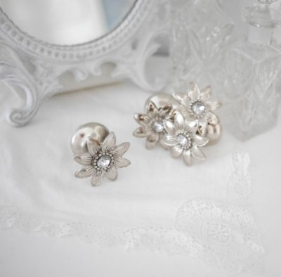 Vacker och elegant silverfärgad metall knopp formad som en blomma. Med fina detaljer och snygga drag. Dekorerad med en diamant f