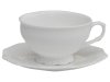 Vit Fransk Te kopp med fat i porslin. Detaljrik med vackert mönster runt om i det vita porslinet. Koppen står på en liten fot oc