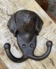Vacker detaljrik krok i järn. Antik brun i nyansen och dekorerad med ett ansikte av en hund och två krokar. Höjd: ca 10cm Bredd