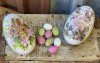 Påskägg /dekorations ägg i plåt. Med vackert motiv av kaniner omgivna av blommor på vit botten. Finns i två modeller -Mörkbruna