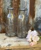Vaser / flaskor i glas som står i en nätad rost brun korg med ring formade handtag. Till blommor , förvaring eller dekoration.