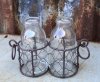 Glas vaser / flaskor som står i en nätad rost brun korg med ring formade handtag. Finns om två modeller -Två flaskor -Tre flasko