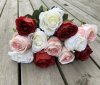 Vit ros med gröna blad och större blomma