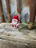 Mindre söt tomte med stickade kläder
