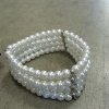 Vackert klassiskt armband med vita pärlor och silver inslag. Bredare i modellen med flera pärlrader bredvid varandra. I elastisk