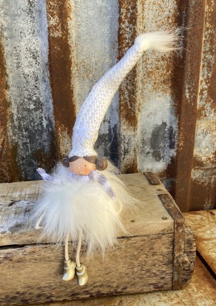 Vit vinter flicka med luva. I modell som kan sitta på en kant och dingla med benen tex. Tillverkad i textil och filt. Detalj fu