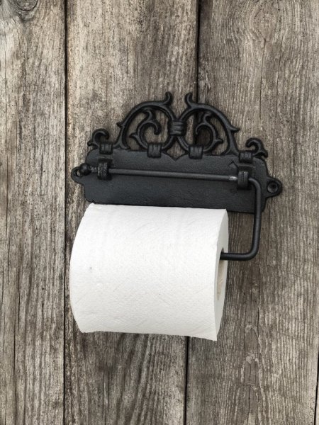 Gammeldags hållare till toalettpapper i järn med snirklig dekoration. I stadig och stabil modell med ledad bygel till pappersrul