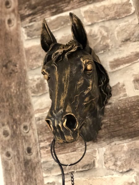 Vacker och annorlunda stor lampa i väggmodell. Häst / hästhuvud i en antik brun nyans med lätta guld inslag . I en kedja hänger