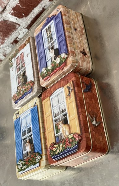 Vacker plåtburk/ask med 3D motiv av en katt i ett fönster på ett hus. Där huset är burken/asken. Finns i fyra olika modeller -Vi