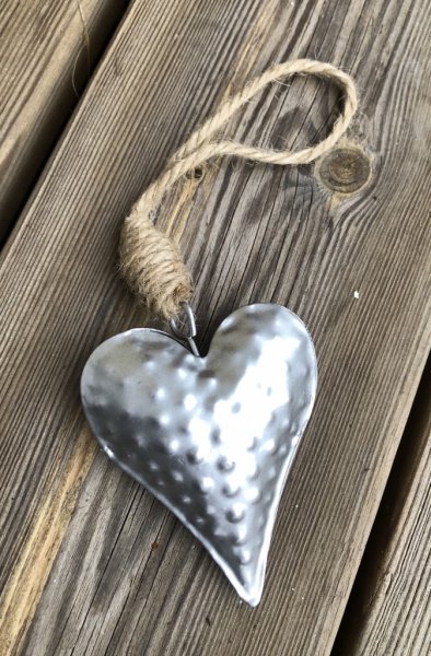 Silver färgat metall hjärta på snöre. Att dekorera pynta och pyssla med. I vacker lätt rundad modell med diskret mönster. Mäter
